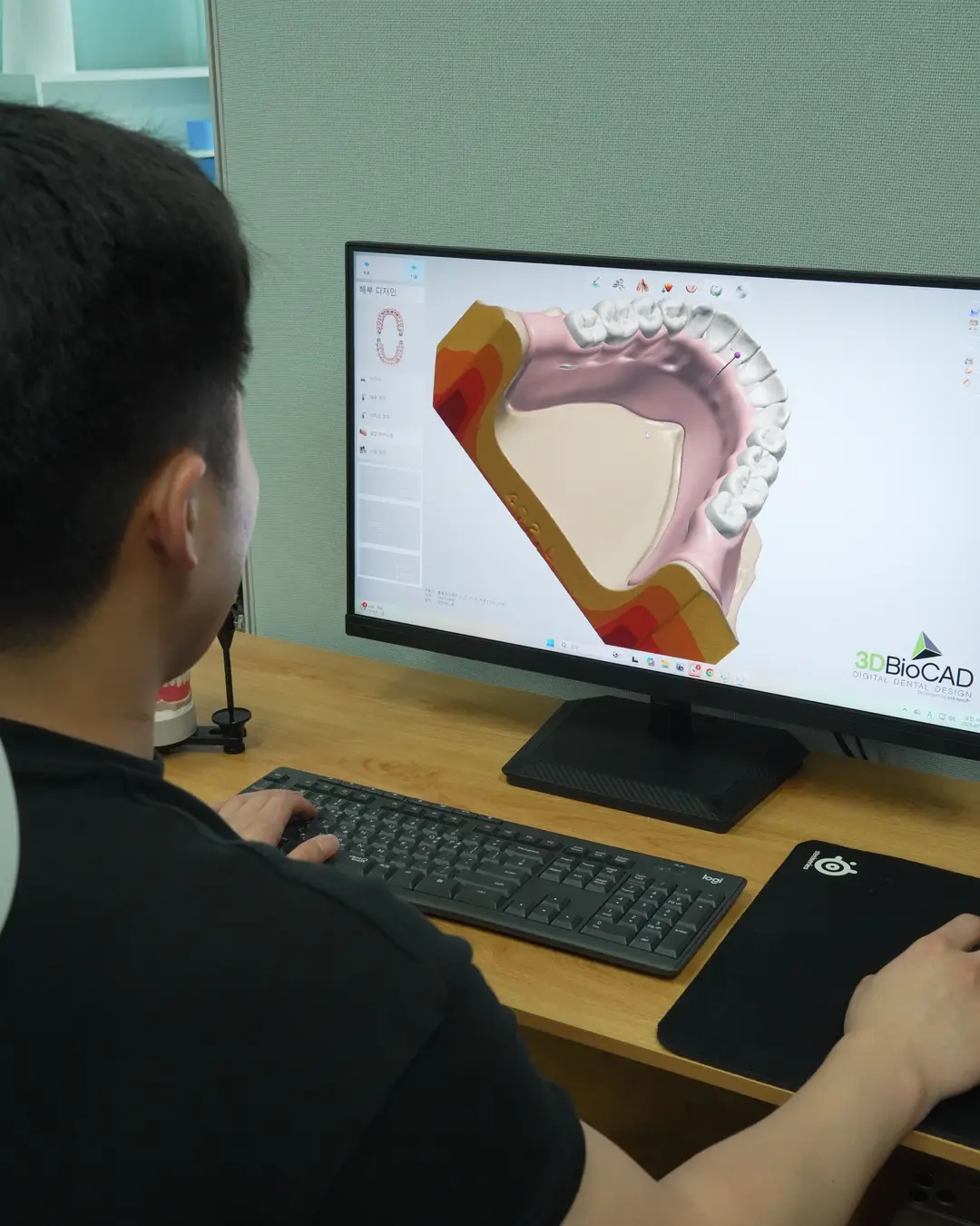 A technician at the CAD screen with a scanned arch open
