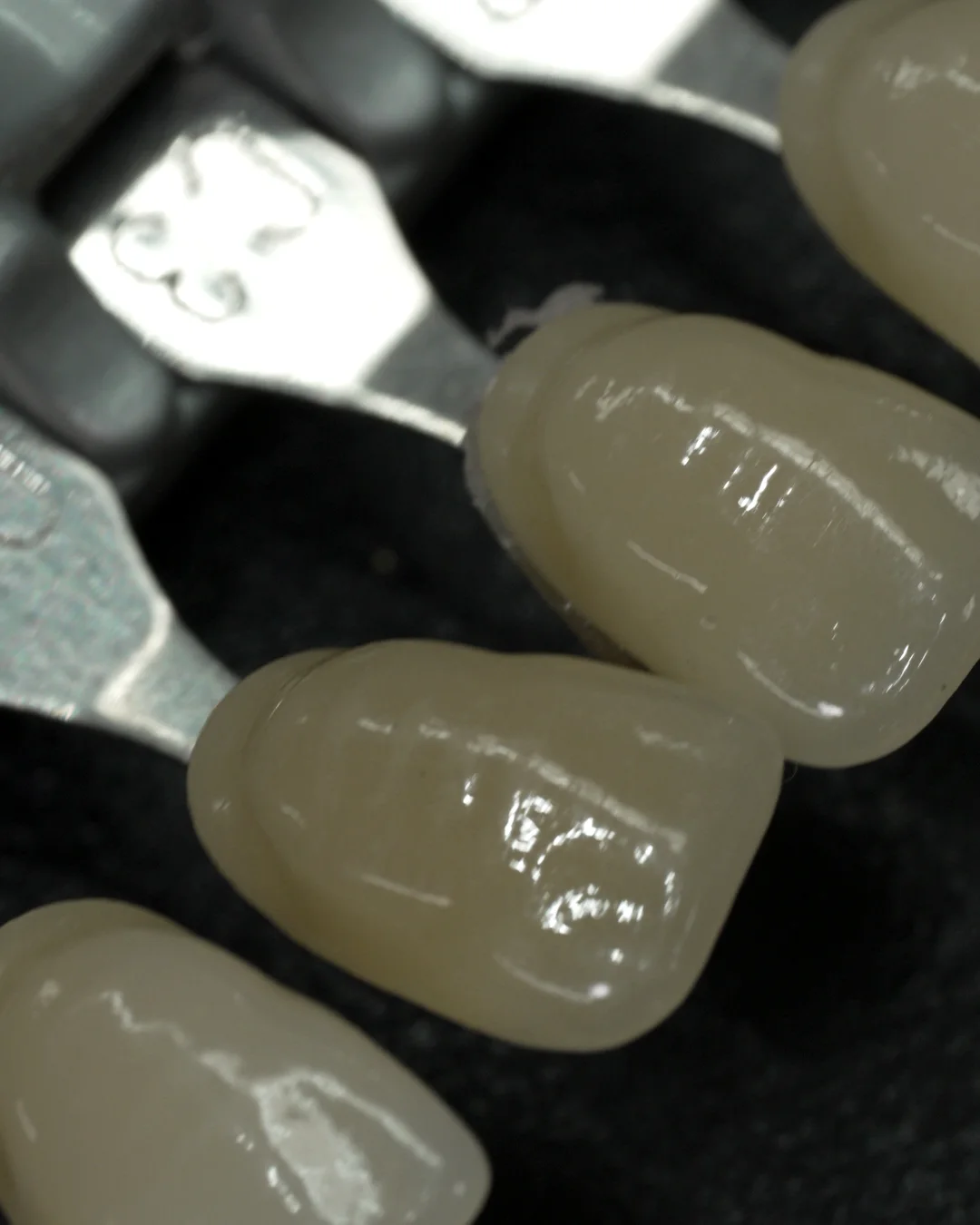 Finished crowns held beside the tabs of a shade guide