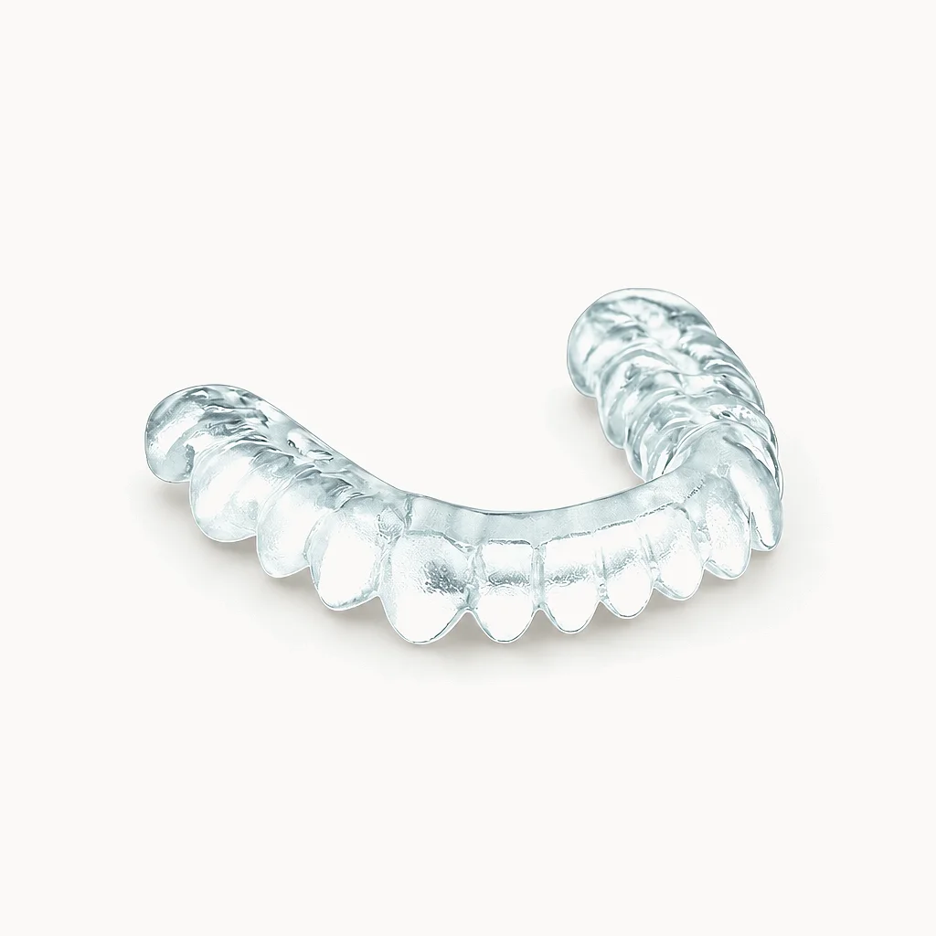 A clear hybrid occlusal splint, soft inside and hard outside, on a white ground