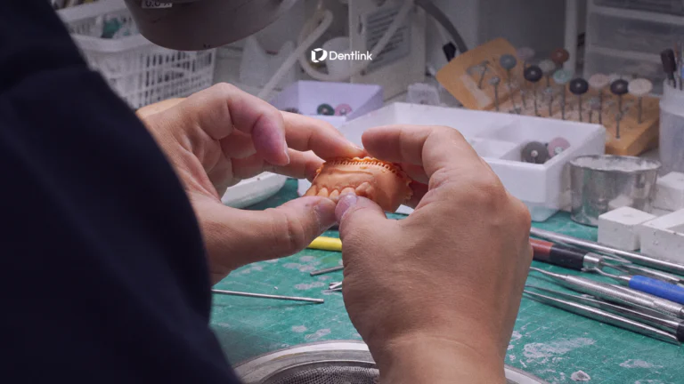 Dentlink master dental technician inspecting a custom restoration during quality control